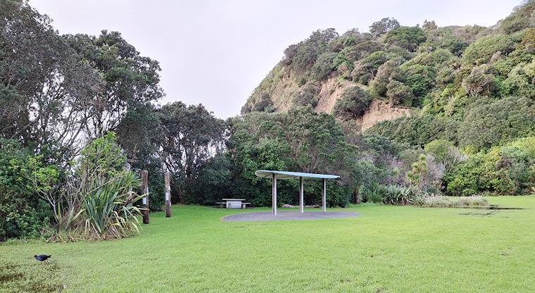 Wenderholm Regional Park - Bookable site two with the shelter, picnic table and trees in the background.