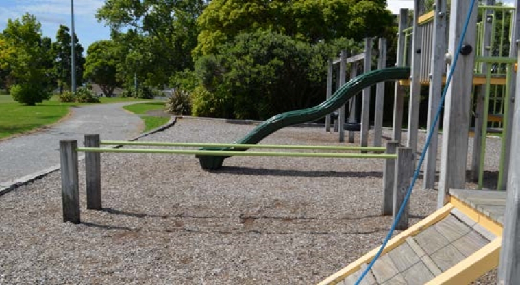 Bayswater Park – Section of the playground showing the parallel bars and slide, and a path running alongside.
