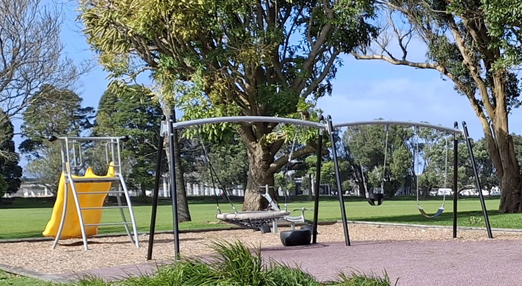 Eastdale Reserve - A set of swings with the slides and seesaw in the background.