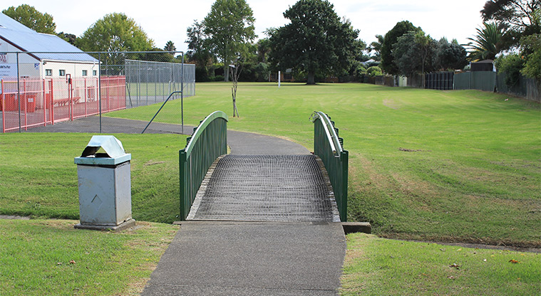 Edith Hopper Park - Small wooden bridge with open grassed area and the tennis club building in the background. Photo credit: M Loubser.