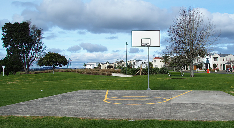 Jack Pringle Sports Park - Basketball half-court with open green space and a seat in the background. Photo credit: Tracey Hodder.