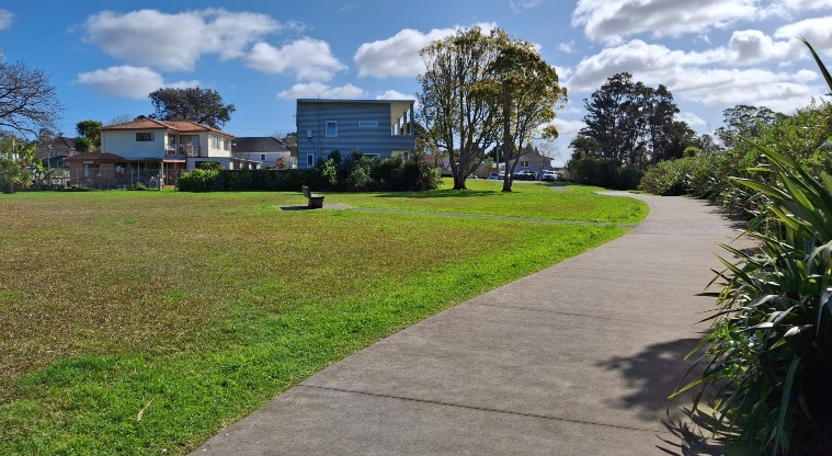 Horowai / Roberts Field – A section of path with open grassed space on the left.